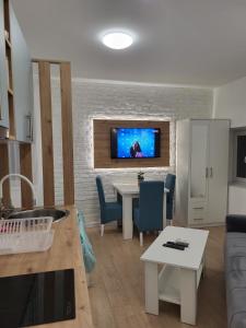 a living room with a table and a tv on a brick wall at HARMONY Suites (Savska ulica) in Sajmište +28 photos