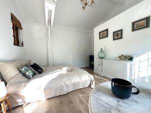ein weißes Schlafzimmer mit einem Bett und einem Tisch in der Unterkunft Chambre d'hôtes Cabanon à 10 min d'Aix-en-Provence in Aix-en-Provence