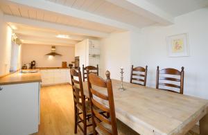 a kitchen and dining room with a wooden table and chairs at Strandhaus Falshöft 3 in Nieby