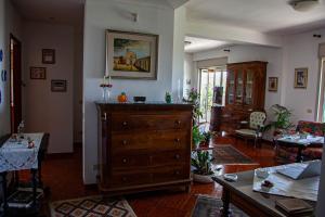 a living room with a large wooden dresser in a room at MAGIA & EMOZIONI - Trecastagni- Area etnea Villa vista mare in Trecastagni