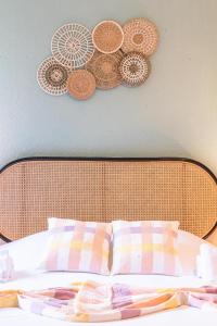 a bed with a wooden headboard with plates on the wall at Centre - L'escale - Petite France in Strasbourg