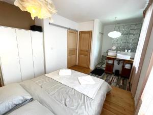 um pequeno quarto com uma cama e um lavatório em Charmant 2 pièces atypique em Mulhouse