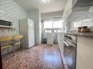 a kitchen with white appliances and a red tile floor at Puerto de Lo Pagan in San Pedro del Pinatar