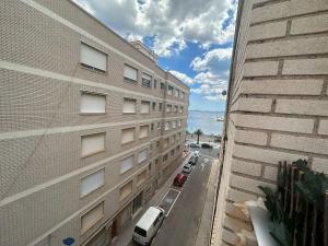 an apartment building with cars parked in a parking lot at Puerto de Lo Pagan in San Pedro del Pinatar