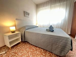 1 dormitorio con cama, lámpara y ventana en Puerto de Lo Pagan, en San Pedro del Pinatar