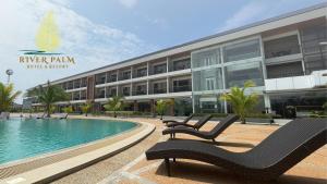 een resort met een zwembad en een gebouw bij River Palm Hotel and Resort powered by Cocotel in Bugallon