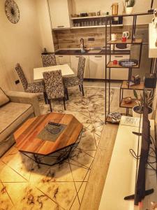 ein Wohnzimmer mit einem Tisch und Stühlen sowie eine Küche in der Unterkunft Milmari Resort N56 Kopaonik free wellnes&spa in Kopaonik