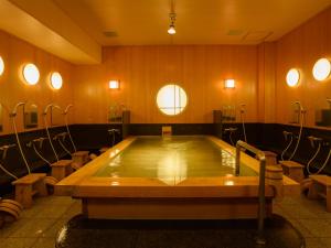 a jacuzzi tub in a room with wooden walls at Ryokan Kohro in Kyoto