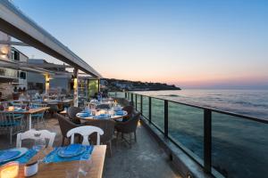 a restaurant overlooking the ocean with tables and chairs at Thalassa Apartments in Rethymno
