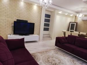 a living room with a couch and a tv at Villa Beyazıt in Side