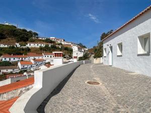 a balcony of a house with a view of a town at Casa das Piteiras nº3 - Aljezur in Aljezur