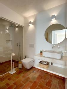 a bathroom with a toilet and a sink and a mirror at Casa das Piteiras nº3 - Aljezur in Aljezur