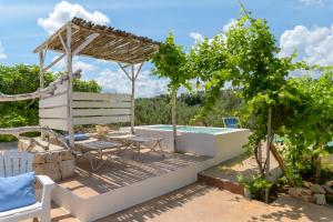 un patio con piscina, mesa y silla en Trullo Solleone con piscine by Wonderful Italy, en Carovigno