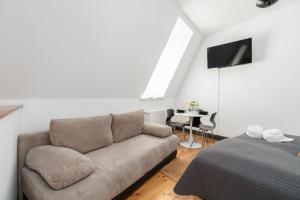 a living room with a couch and a bed at Apartments Poznań Strzałowa by Renters in Poznań