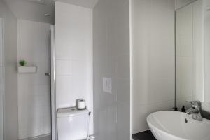 a white bathroom with a toilet and a sink at L'Armateur - Appartement intramuros - plage - St Malo in Saint Malo