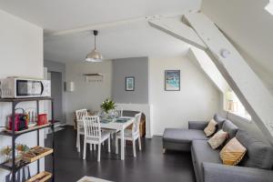 uma sala de estar com um sofá e uma mesa em L'Armateur - Appartement intramuros - plage - St Malo em Saint Malo