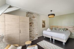 um quarto com uma cama e uma parede de pedra em L'Armateur - Appartement intramuros - plage - St Malo em Saint Malo
