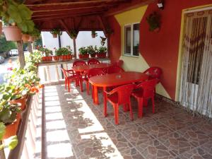 une rangée de chaises rouges et de tables sur une terrasse dans l'établissement Casa de vacanta, à Eforie Nord