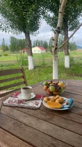 a table with a bowl of fruit and a cup of coffee at VILLA VIP in Sevan