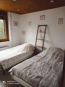 a bedroom with two beds and a ladder in it at Calme et détente dans une maison proche de la mer in Neufchâtel-Hardelot