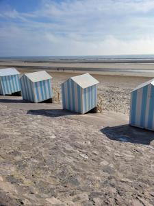 four blue and white containers sitting on the beach at Calme et détente dans une maison proche de la mer in Neufchâtel-Hardelot