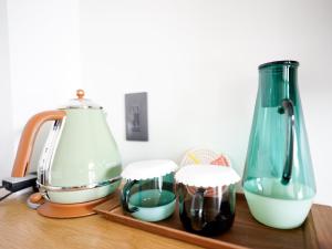 two vases and two cups on a wooden shelf at ＨＯＴＥＬ ＬＯＣＡＬ ＢＡＳＥ＜宮古島＞ in Miyako Island