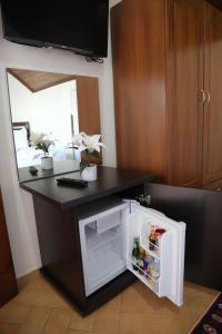 a small refrigerator with its door open in a kitchen at DEAL Castle View Rooms in Krujë