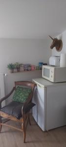 krzesło przy blacie z kuchenką mikrofalową w obiekcie Chez Margarett w mieście Royan