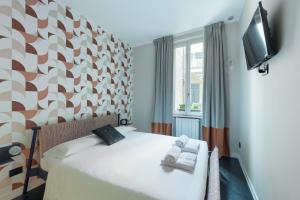 um quarto com uma cama, uma televisão e uma janela em HL Luxury Apartment - Duomo, Via Torino, Montenapoleone em Milão