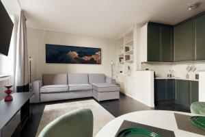 uma sala de estar com um sofá e uma cozinha em HL Luxury Apartment - Duomo, Via Torino, Montenapoleone em Milão