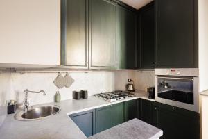 uma cozinha com armários verdes e um lavatório em HL Luxury Apartment - Duomo, Via Torino, Montenapoleone em Milão