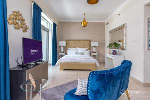 ein Schlafzimmer mit einem Bett, einem TV und einem Sofa in der Unterkunft Dream Inn Apartments - Burj Views in Dubai