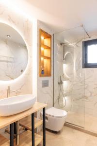 a bathroom with a toilet and a glass shower at Five Senses Of Luxury in Kalandra