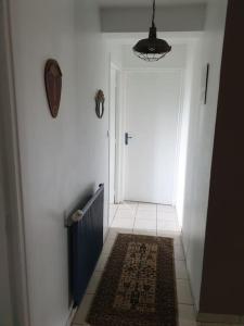 un pasillo con una puerta y una alfombra delante de ella en Appartement 6 pers sur l'Aubrac, 