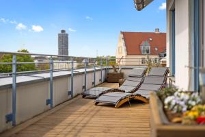d'un balcon avec bancs et vue sur un bâtiment. dans l'établissement Arbio I Premium Penthouse Apartment Augsburg, à Augsbourg