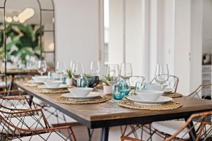 a long wooden table with plates and glasses on it at Arbio I Premium Penthouse Apartment Augsburg in Augsburg
