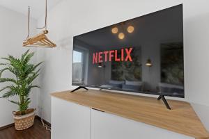 einen TV im Wohnzimmer mit einem Netflix-Schild darauf in der Unterkunft Arbio I Premium Penthouse Apartment Augsburg in Augsburg