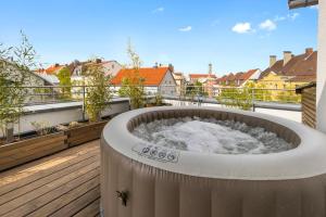 a hot tub on the roof of a building at Arbio I Premium Penthouse Apartment Augsburg in Augsburg