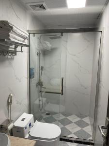 a bathroom with a toilet and a glass shower at Trung Đức Homestay in Móng Cái