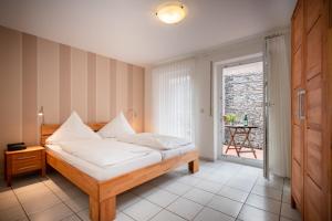 Schlafzimmer mit einem Bett mit weißer Bettwäsche und einem Fenster in der Unterkunft Weingut Josef Ehses in Traben-Trarbach