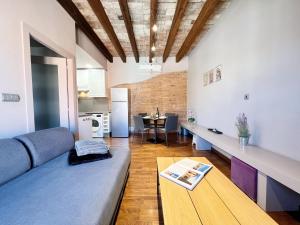 ein Wohnzimmer mit einem Sofa und einem Tisch in der Unterkunft Suite Gracia Barcelona in Barcelona