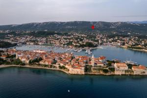 a hot air balloon flying over a small island in the water at Apartmani Pero Dido in Rab