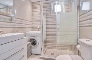 a bathroom with a washer and dryer in it at #Seashell by halu! in Nea Fokea