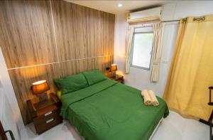 邦涛海滩The Endless Bangtao Residence ST2的一间带绿色床和窗户的卧室