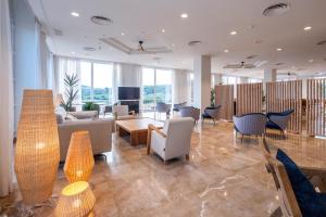 a lobby with chairs and a couch and a table at HG Jardín de Menorca in Son Bou