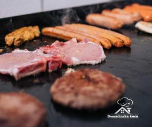 a grill with meat and vegetables on it at Domaćinska Kuća Banja Luka in Banja Luka