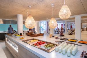 a buffet line in a building with food on it at HG Jardín de Menorca in Son Bou