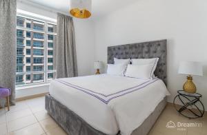 ein Schlafzimmer mit einem großen Bett und einem großen Fenster in der Unterkunft Dream Inn Apartments - Burj Views in Dubai