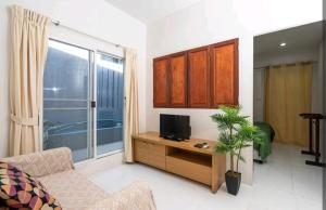 邦涛海滩The Endless Bangtao Residence ST2的客厅配有沙发和桌子上的电视