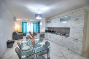uma cozinha e sala de jantar com uma mesa de vidro e cadeiras em Spacious & modern 3 bedroom near seafront JBOR1-1 em Il-Gżira